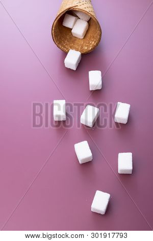 Flying Sugar Concept. Flying Sugar Cubes From Ice Cream Cone On Red Background. Copy Space For Text.