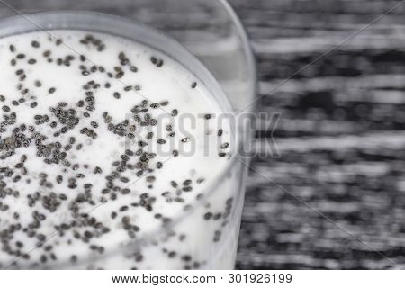 Cocktail Of Yogurt And Chia Seeds In A Glass On A Dark Wooden Old Table