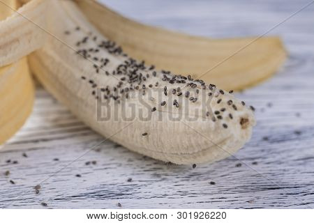 A Half-peeled Banana With Chia Seeds Poured On It