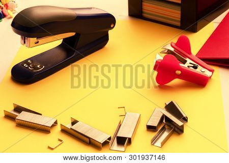 Stapler, Paper Clips, Anti-stapler On The Desktop On The Background Of Stickers And Folder In Isolat