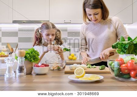 Mother And Child Cooking Together At Home In Kitchen. Healthy Eating, Mother Teaches Daughter To Coo