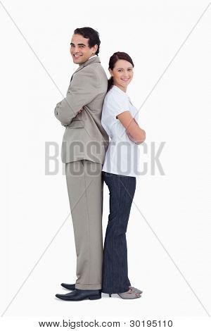Smiling salesteam standing back to back against a white background