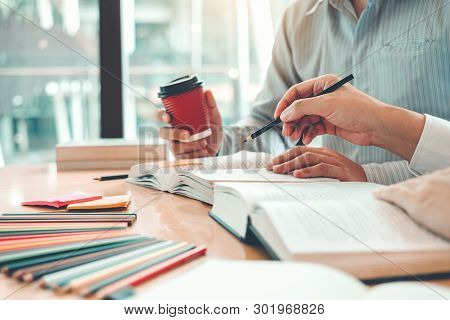 High School Or College Students Studying And Reading Together In Library