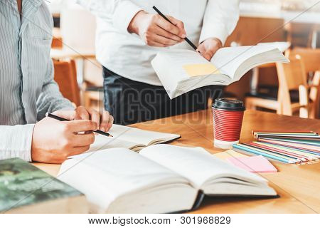 High School Or College Students Studying And Reading Together In Library