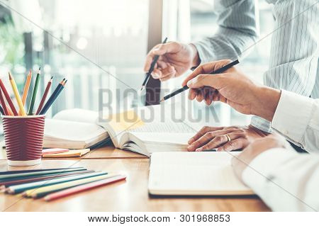 High School Or College Students Studying And Reading Together In Library