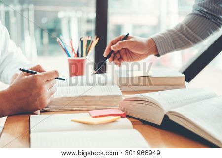 High School Or College Students Studying And Reading Together In Library