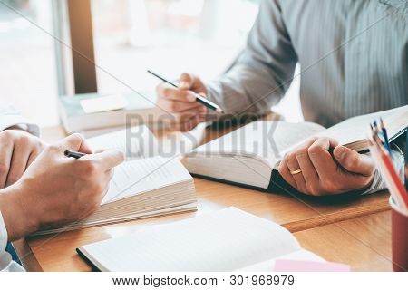 High School Or College Students Studying And Reading Together In Library