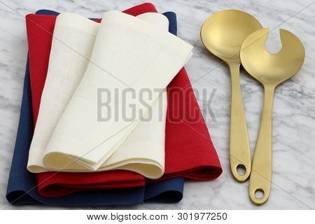 Trendy And Beautiful Golden Serving Spoon And Fork Set Styled With Hemstitch Linen Napkin