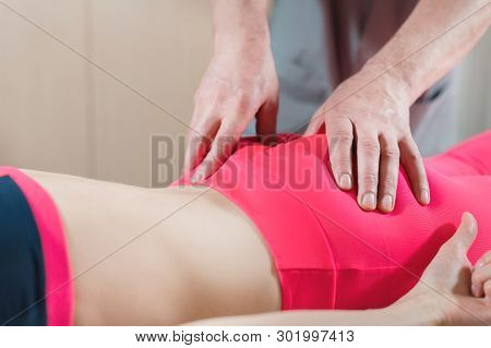 Close-up Of A Young Girls Spine Base Editing By A Male Physiotherapist Of Visceral Massage. The Hand
