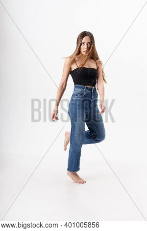 Young Attractive Asian Woman With Long Hair In Black Top, Blue Jeans Isolated On White Studio Backgr
