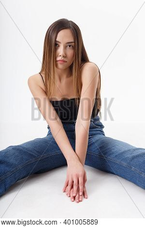 Young Attractive Asian Woman With Long Hair In Black Top, Blue Jeans Isolated On White Studio Backgr