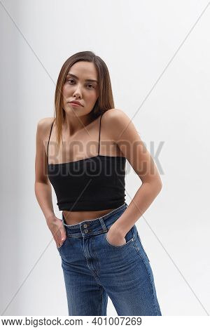 Portrait Of Young Attractive Asian Woman With Long Hair In Black Top, Blue Jeans Isolated On White S