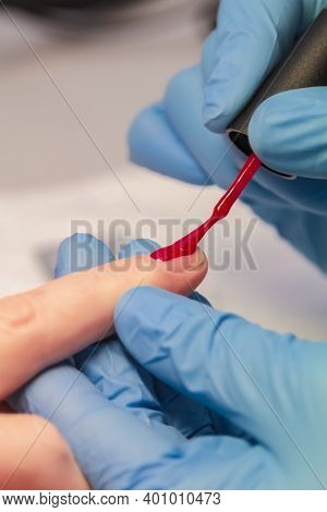 Close-up Of A Woman Applying Red Nail Polish. Womens Beauty Service