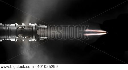 Copper Plated Bullet With Smoking Flying From A Flash Hider On An Ar-15 On A Black Background.