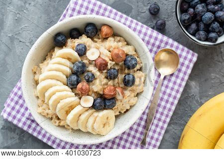 Oatmeal Porridge With Blueberry, Banana And Hazelnut. Vegan Vegetarian Porridge Oats With Fruits And