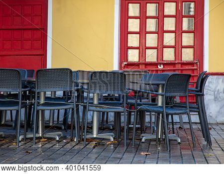 Restaurant Cafe Tables And Seats Tied With Metal String In Front Of Closed And Locked Shop, Covid 19