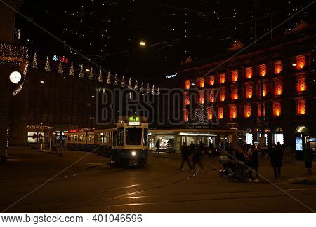 Paradeplatz At Christmastime At Night. Illuminated Windows Of Headquarter Of Banks And Tram Station 