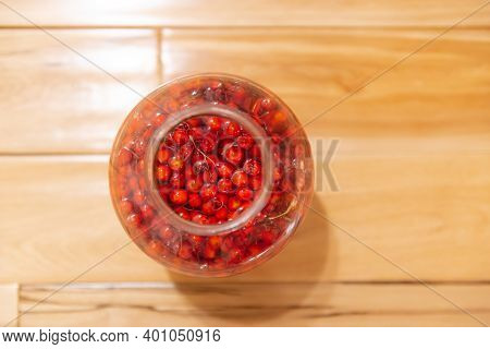 Manufacturer Of Tincture Of Mountain Ash. Rowan Berries In A Glass Jar. Vodka Poured Red Berries.