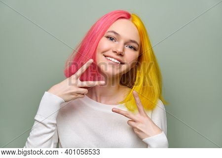 Head Shot Of Fashionable Beautiful Teenage Girl Showing Victory Gesture With Fingers, Female With Tr