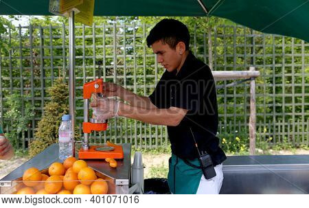 Versailles, France - June 08, 2013: Young Man Prepares Fresh Juice In The Park Of The Palace Of Vers
