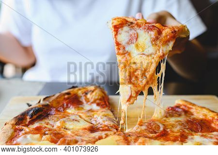 Wood Fire Cheesy Pizza Slice In Hand. Traditional Hawaiian And Salami Pizza Savory Dish Flavour Of O
