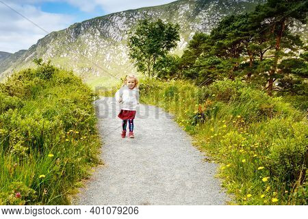 Cute Little Happy Toddler Girl Running On Nature Path In Glenveagh National Park In Ireland. Smiling