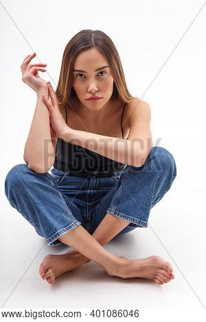 Young Attractive Asian Woman With Long Hair In Black Top, Blue Jeans Isolated On White Studio Backgr