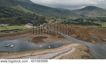 Landscape of mountains valley. Nobody nature seascape. Village at whisky distillery. Cinematic yachts, ships on ocean bay. Water of Loch Ranza bay, Arran Island, Scotland, United Kingdom, Europe