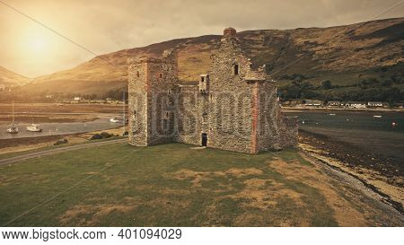 Closeup castle ruins at sun sea coast aerial. Historical heritage of British culture. Ancient tourist attraction. History landmark close up. Cinematic Loch-Ranza Bay, Arran island, Scotland, Europe