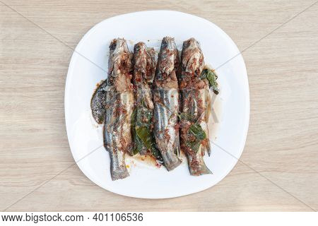Top View Of Fried Twospot Catfish With Spawn In Red Spicy Curry Sauce Or Chuchee In White Plate On W