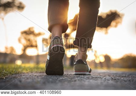 Woman Walking Outdoors On Sunset. Closeup On Shoe With Rolled Up Jeans. Taking A Step. New Life Conc