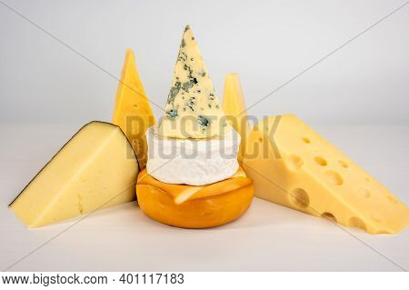 Different Types Of Delicious Cheese On Grey Background. Blue Cheese Dorblu, Smoked Suluguni, Brie, M
