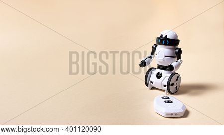 Robot On A Light Beige Background. A Toy For A Boy On The Radio Control With A Remote Control With A