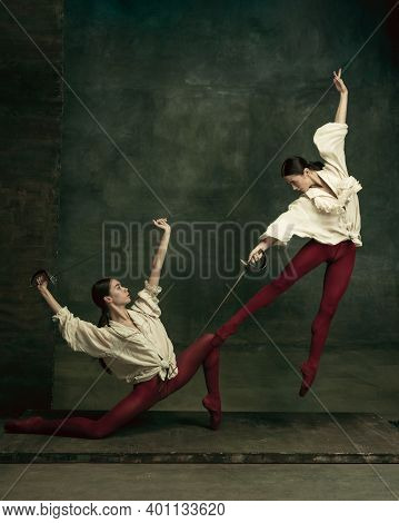 Flying. Two Young Female Ballet Dancers Like Duelists With Swords On Dark Green Background. Caucasia