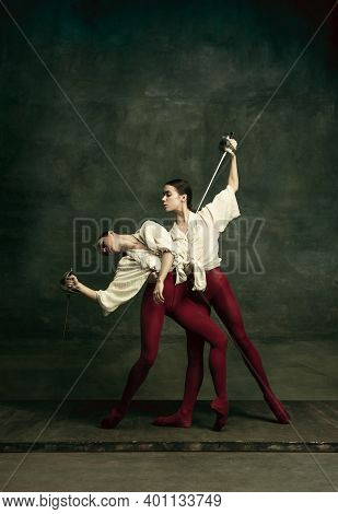 Passioned. Two Young Female Ballet Dancers Like Duelists With Swords On Dark Green Background. Cauca