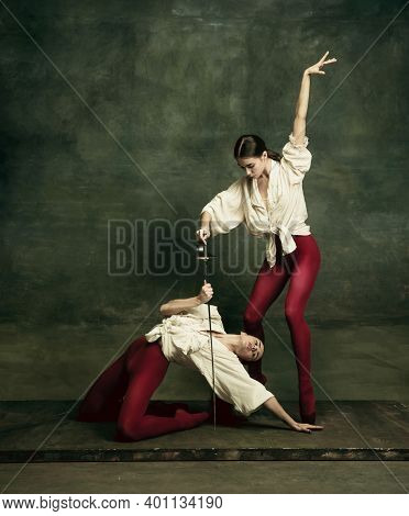 Action. Two Young Female Ballet Dancers Like Duelists With Swords On Dark Green Background. Caucasia