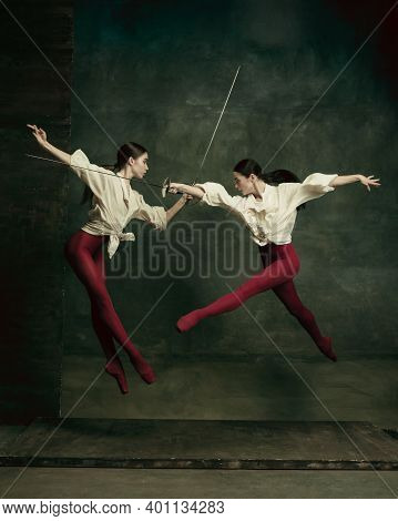 Fatal. Two Young Female Ballet Dancers Like Duelists With Swords On Dark Green Background. Caucasian