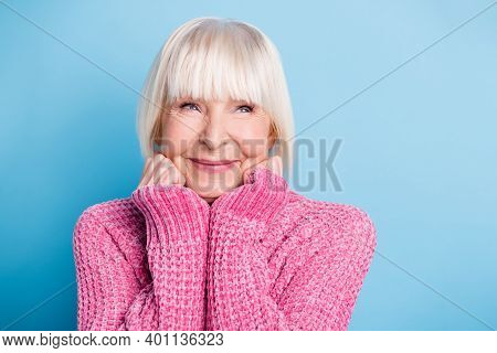 Photo Of Positive Woman Arms On Cheeks Look Empty Space Wear Pullover Isolated On Blue Color Backgro