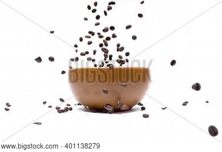 Flying Coffee Beans Into A Brown Bowl On A White Background, Close-up. Blurred. Selective Focus. Dyn
