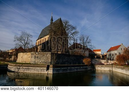 City Fortifications And Pond With Water Near Gothic Church Of Saint Gothard With Bell Towers In Cent