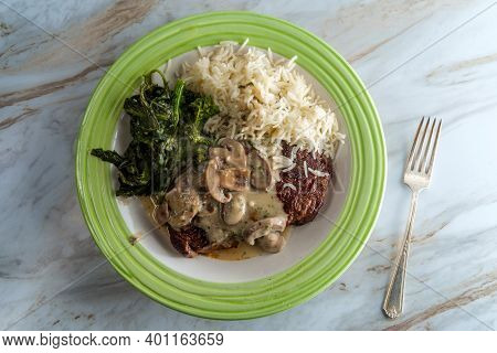 Grilled Club Steak With Creamy Marsala Wine Mushroom Sauce And Sides Of Rice And Broccoli Rabe