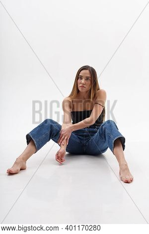 Young Attractive Asian Woman With Long Hair In Black Top, Blue Jeans Isolated On White Studio Backgr