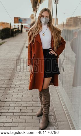 Young Ukrainian Blonde Woman In Protective Medical Mask Kn95 Respirator On Street Against Background