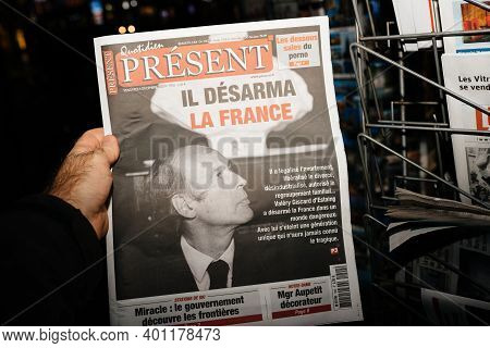 Strasbourg, France - Dec 4, 2020: Pov Male Hand Holding Quotidien Present Newspaper At French Press 