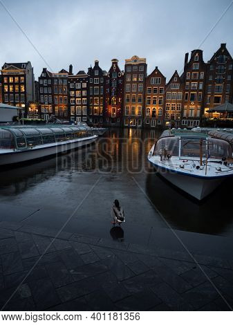 Twilight View Of Duck At Boat Dock At Famous Dancing Houses On Damrak Gracht Central Amsterdam In Ho
