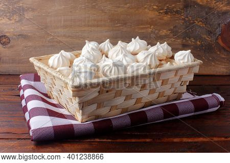 Sigh Or Homemade Meringue Is A Sweet Made From Egg Whites, Sugar And Lemon In The Basket On Wooden T