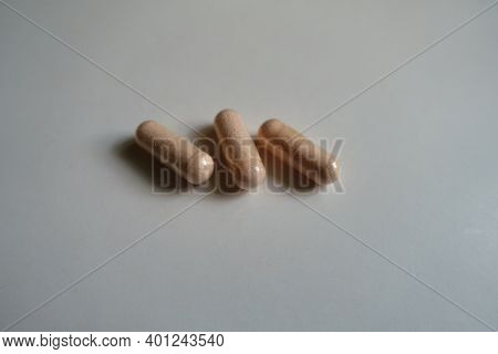 Group Of Three Pink Capsules Of Probiotic Dietary Supplement