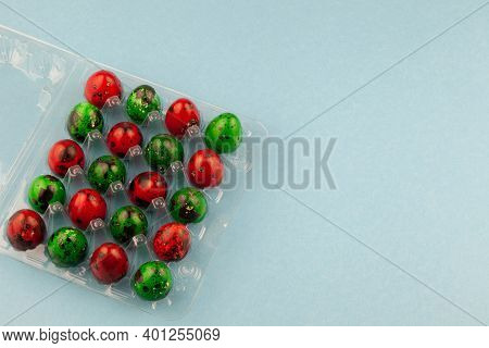 Multicolored Quail Eggs Green And Red On A Blue Background With Place For Text. Happy Easter Postcar