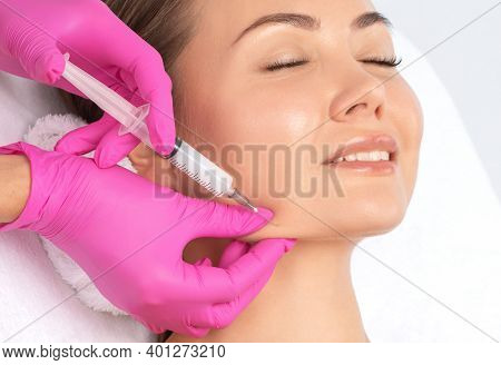 Cosmetologist Makes Lipolytic Injections To Burn Fat On The Chin, Cheeks And Neck Of A Woman Against