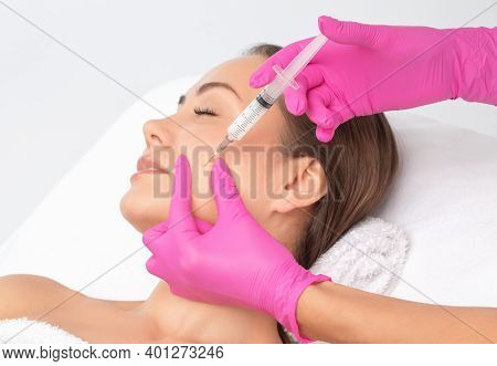 Cosmetologist Makes Lipolytic Injections To Burn Fat On The Chin, Cheeks And Neck Of A Woman Against